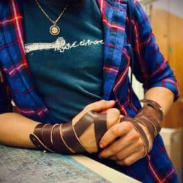 a man with blue flannel wearing a Woven leather Cuff - renaissance clothing - renaissance clothing men - renaissance clothing women - renaissance clothing near me - renaissance art clothing - renaissance era clothing - renaissance costume ideas