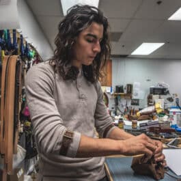 A woman is working on her Bison Leather Sleeve Garters.
