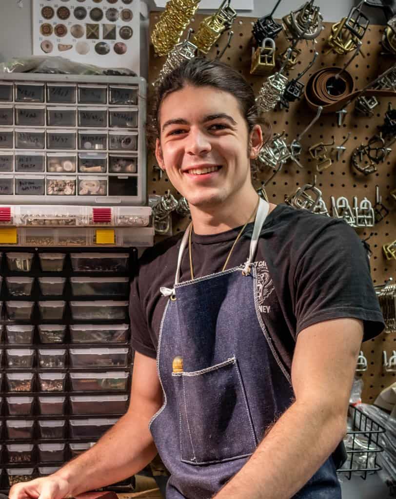 a man standing in front of a rack of jewelry.