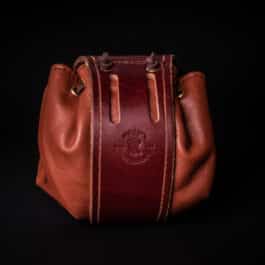 a brown Handmade Leather Dice Bag on a black background.