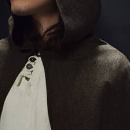 a man with long hair wearing a brown wool tweed hooded cloak - renaissance clothing - renaissance clothing men - renaissance clothing women - renaissance clothing near me - renaissance art clothing - renaissance era clothing - renaissance costume ideas