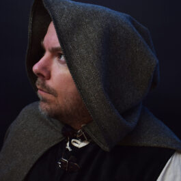 a man wearing a wool tweed hooded cloak looking upward - renaissance clothing - renaissance clothing men - renaissance clothing women - renaissance clothing near me - renaissance art clothing - renaissance era clothing - renaissance costume ideas
