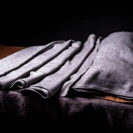 A pile of folded Ranger Bedrolls on top of a wooden table.
