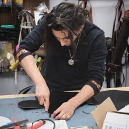 A woman working on Upgraded Leather Sleeve Garters.