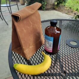 a Waxed Canvas Lunch Bag sitting on top of a metal table.