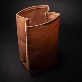 A Waxed Canvas Lunch Bag sitting on top of a black table.