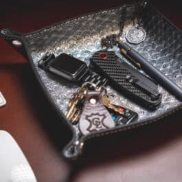 A Blue Mythical Koi Suede Lined Valet Tray with a keyboard, keys, and wallet on it.