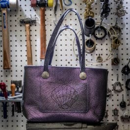 A Burgundy Mythical Koi Suede Lined Valet Tray sitting on top of a table.