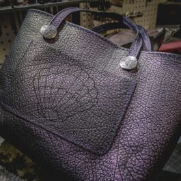 A Burgundy Mythical Koi Suede Lined Valet Tray sitting on top of a table.