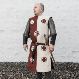 a man wearing a burgundy and cream linen surcoat with crosses on the front