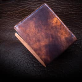 An Emerald Green Shell Cordovan Bifold Wallet sitting on top of a table.