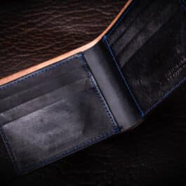An Emerald Green Shell Cordovan Bifold Wallet with a blue stitch on the inside of it.