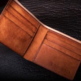 An Emerald Green Shell Cordovan Bifold Wallet sitting on top of a table.