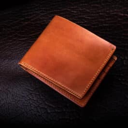 Horween Amaretto Shell Cordovan Bifold Wallet sitting on top of a table.