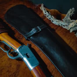 A Handmade Leather Rifle Scabbard rests on the table.