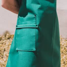 a person wearing a Canvas Apron with a pocket.