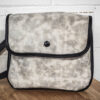 An Ivory Leather Satchel sitting on top of a wooden table.