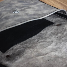 An Ivory Leather Satchel sitting on top of a wooden floor.