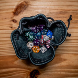 A Leather Dice Pouch sitting on top of a wooden table.
