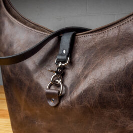 A gray leather bag on a wooden table