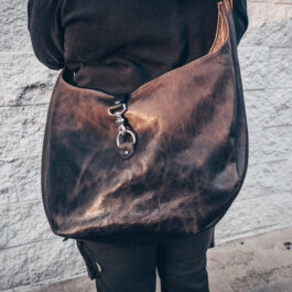 A gray leather bag slung over a womans back