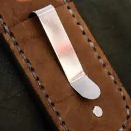 a steel pocket clip attached to a leather sheath