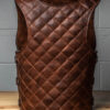 a light brown quilted leather vest on a wooden table