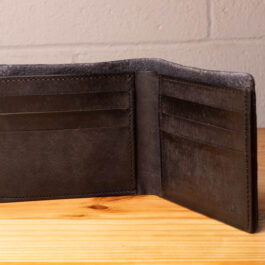 A leather wallet sitting on a wooden table