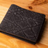 A leather wallet sitting on a wooden table