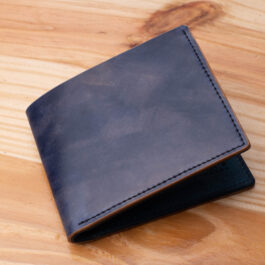 A leather wallet sitting on a wooden table