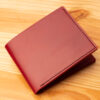 A leather wallet sitting on a wooden table