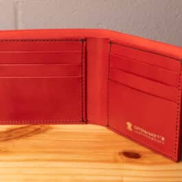 A leather wallet sitting on a wooden table