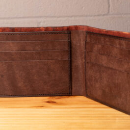 A leather wallet sitting on a wooden table