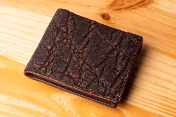 A leather wallet sitting on a wooden table