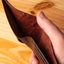 A leather wallet sitting on a wooden table