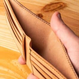 A leather wallet sitting on a wooden table
