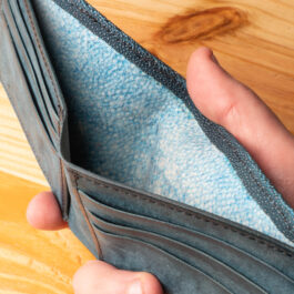 A leather wallet sitting on a wooden table