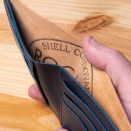 A leather wallet sitting on a wooden table