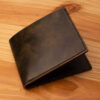 A leather wallet sitting on a wooden table