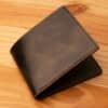 A leather wallet sitting on a wooden table