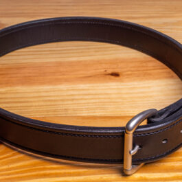 A black Leather belt on a wooden table