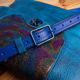 a blue leather bag with rainbow accents