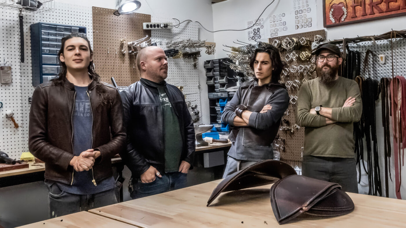 4 handsome men, standing in front of a workbench.