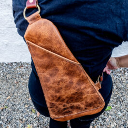 A woman with a leather sling bag on her back