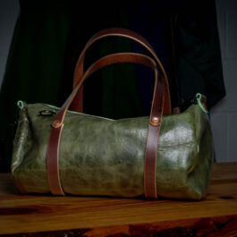 a green bison mini duffel with dark brown handles