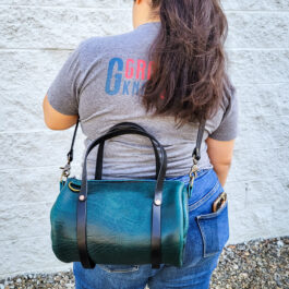 a woman carrying a Bison Leather Mini Duffel on her back.