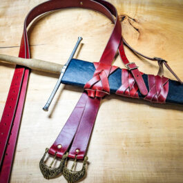 A Wood Core Scabbard for the Albion Meyer and a leather belt on a table.
