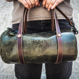 a green bison mini duffel with dark brown handles