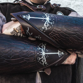 A man in a medieval outfit holding two Strider Vambraces.