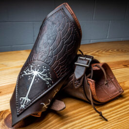 a pair of Strider Vambraces with a dragon design on them.
